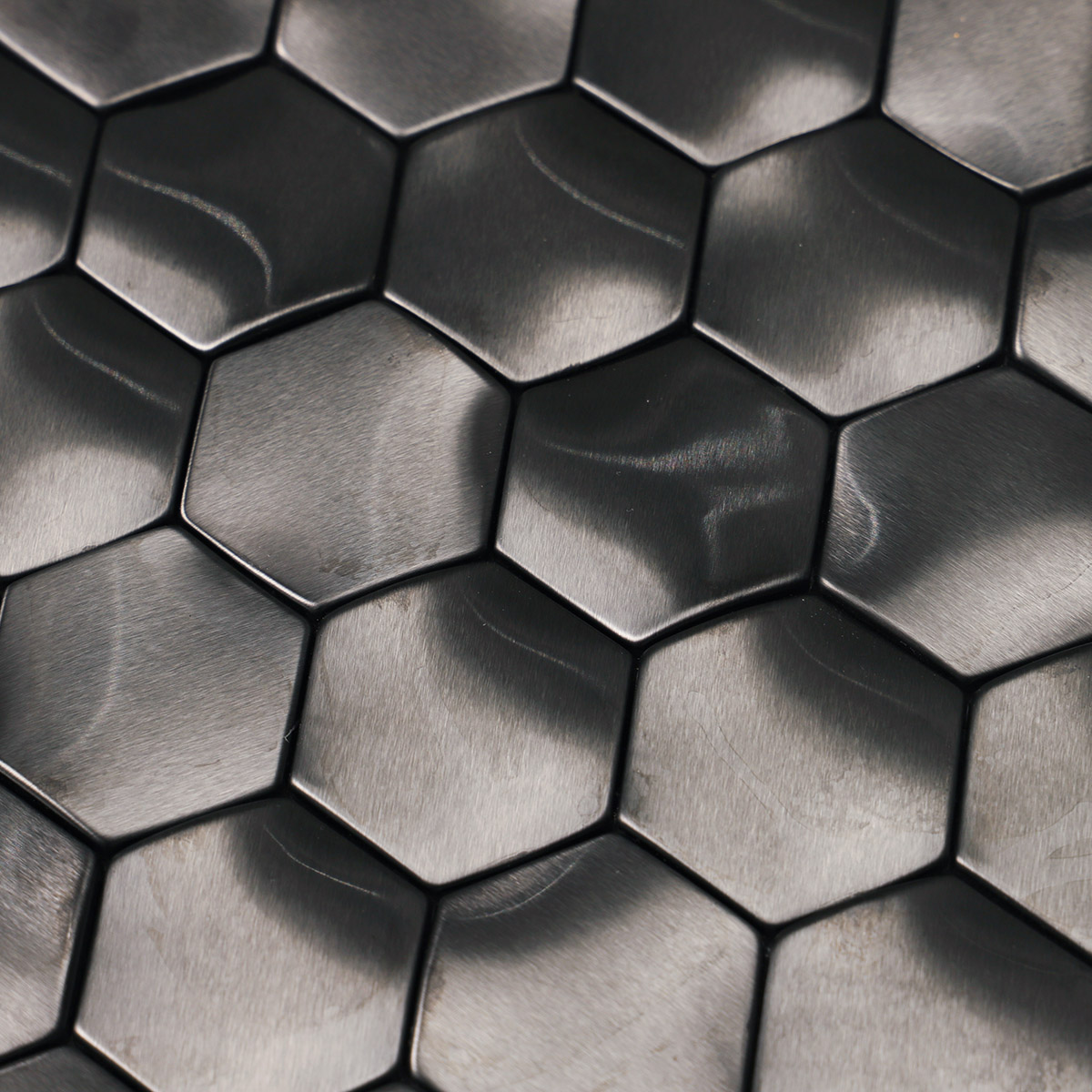 Macro close-up of wavy 3D metal black brushed stainless steel hexagon mosaic tiles.