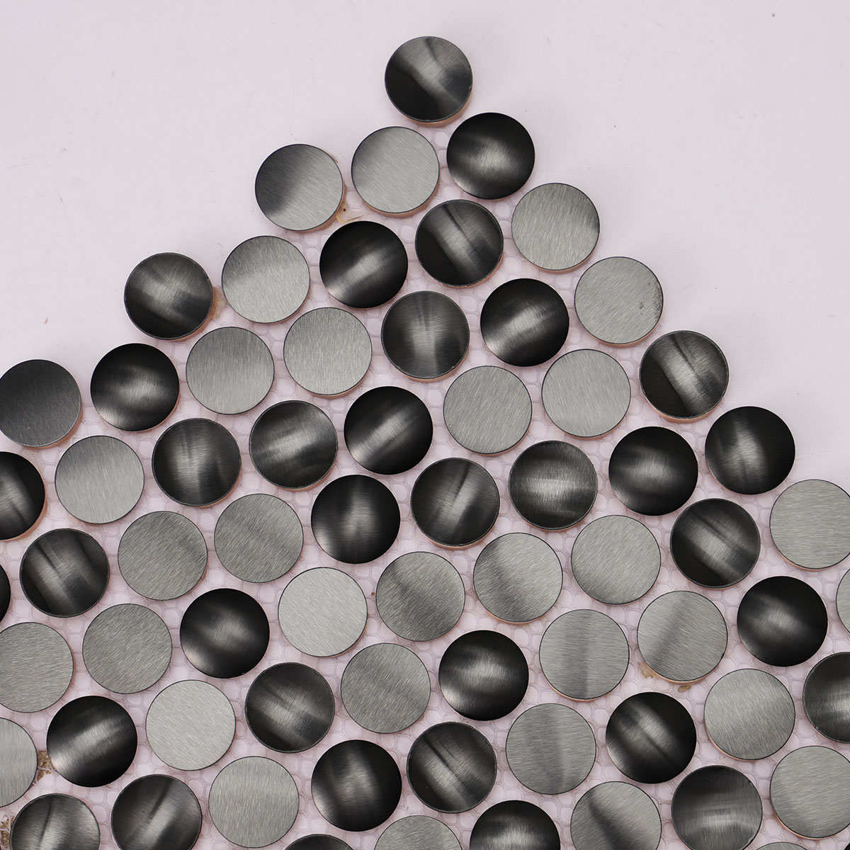 Texture close-up of 3D black penny round metal mosaic tiles.