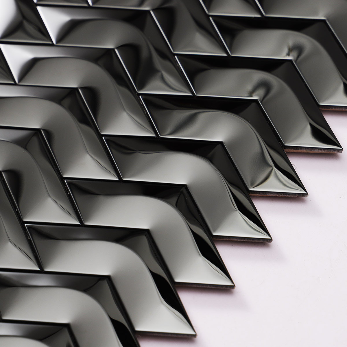 Detailed close-up of black stainless steel chevron 3D mirror mosaic tiles.