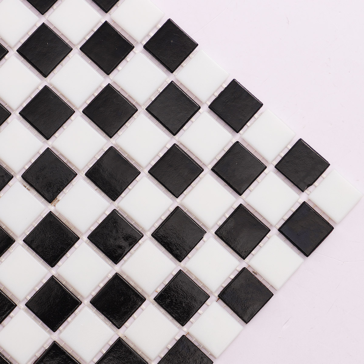 Close-up view of black and white vintage checkerboard mosaic tiles.