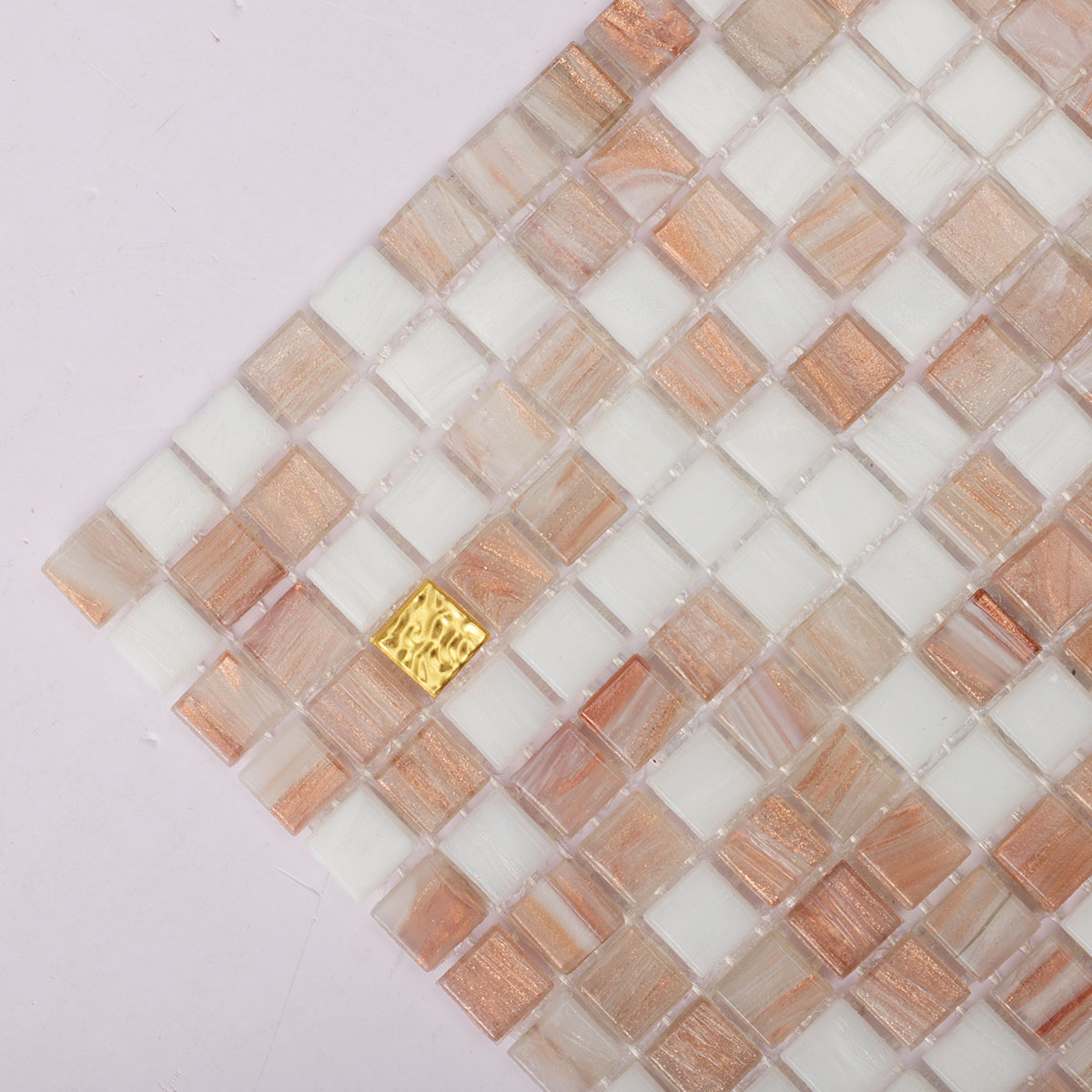 Close-up view of white and beige tiny glass mosaic tiles with 24K gold.