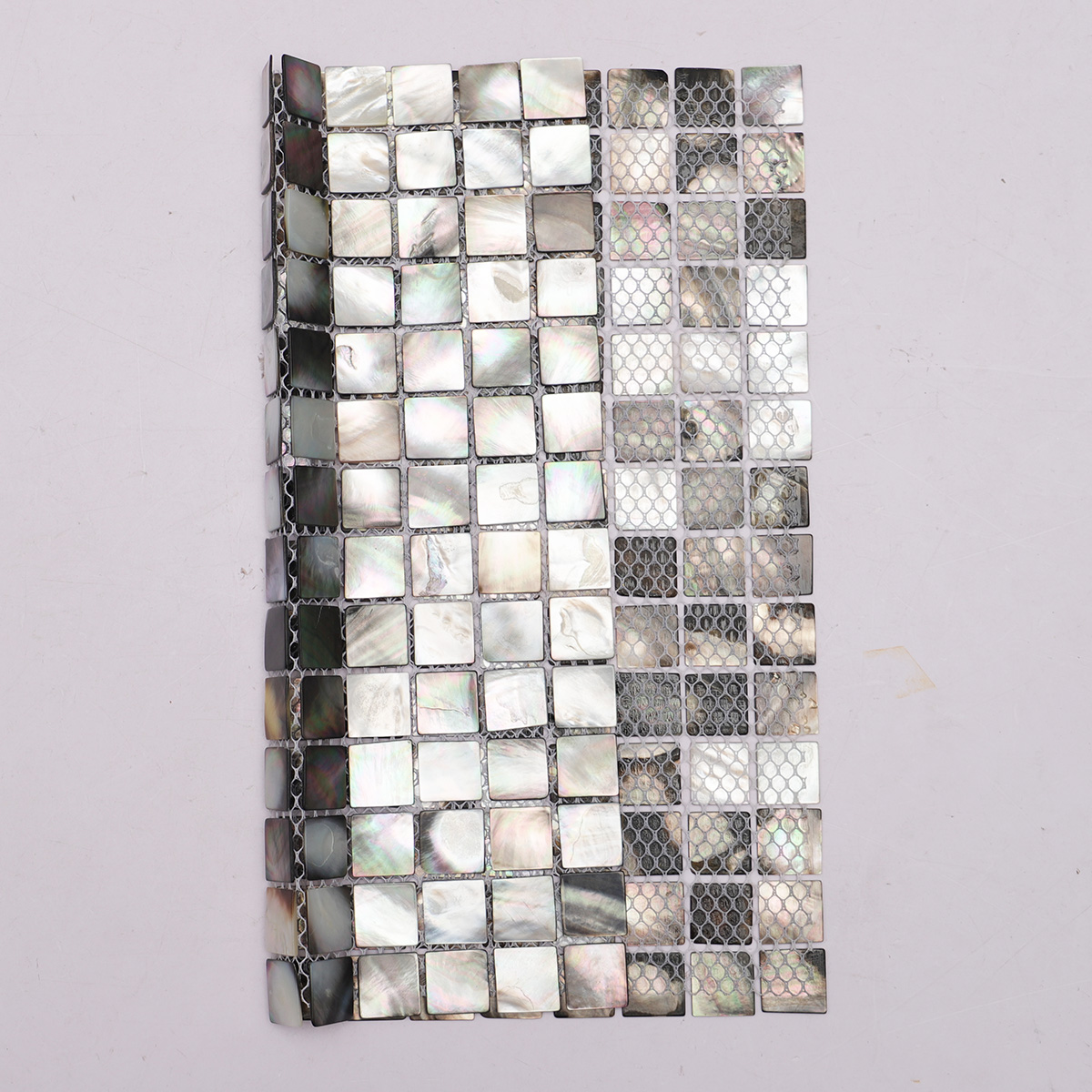 Back side of deep sea black seashell square pattern mosaic tiles, showing fold