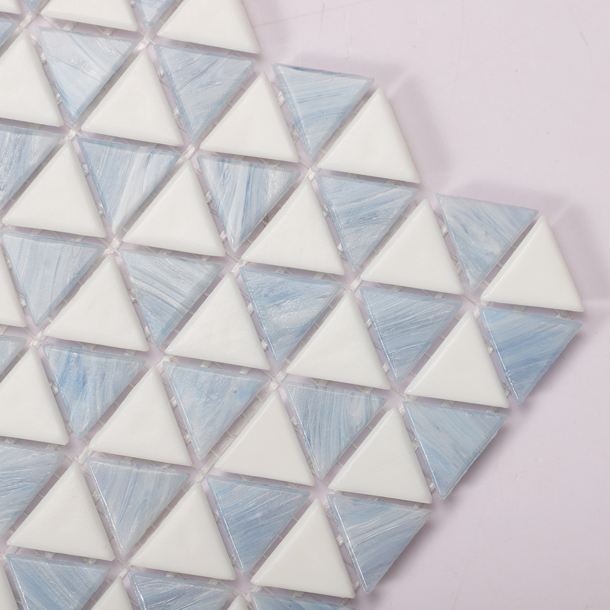 Close-up of blue and white checkerboard triangle glass mosaic tiles.