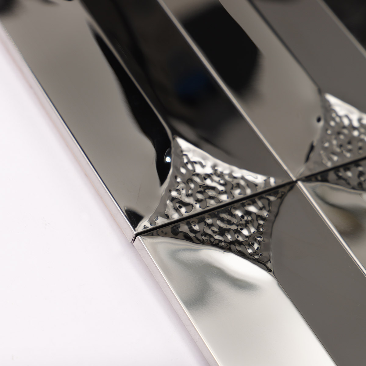 Close-up of the side of 3D glossy silver rectangle metal mosaic tiles