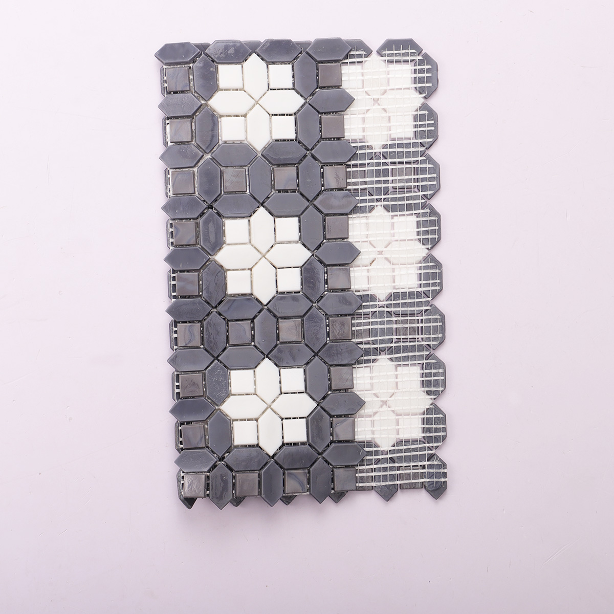 Folded view of back side of gray and white picket with square glass mosaic tiles