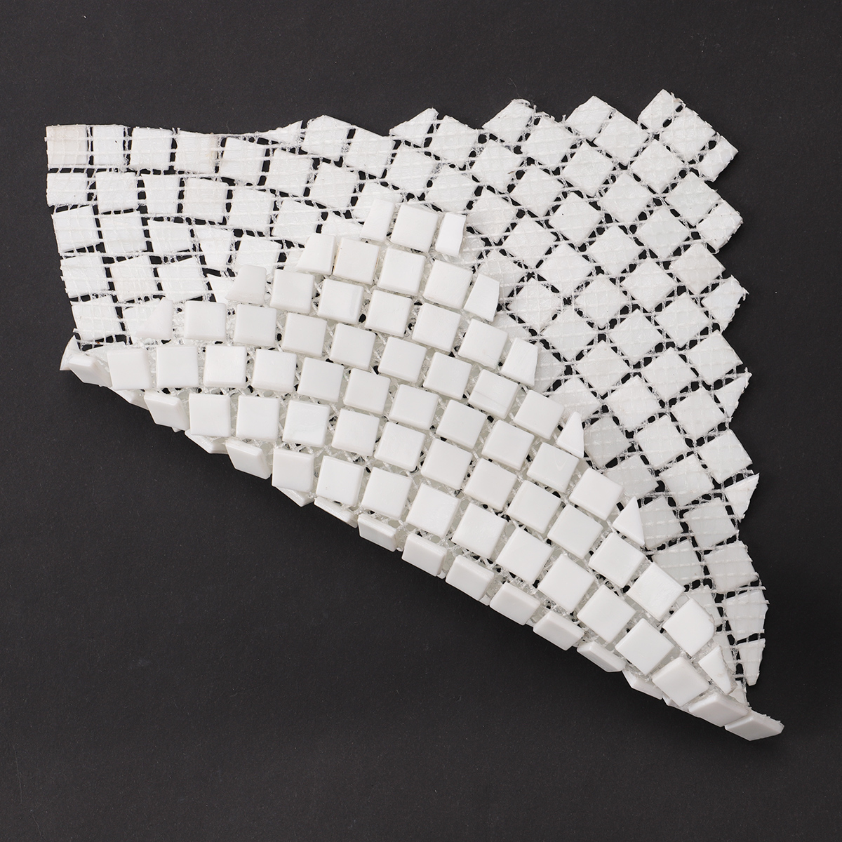 Back side of white glass mosaics with hand-cutting art, folded