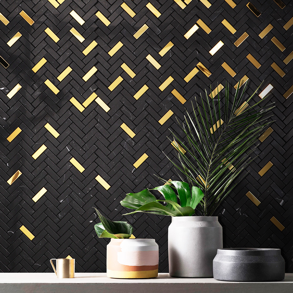 Black marble and gold metal gradient mosaic tiles on a wall.