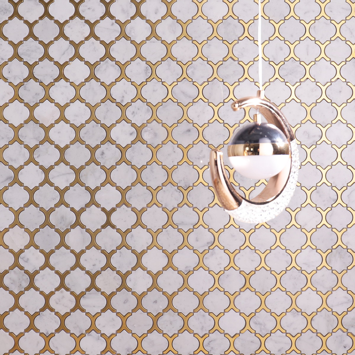 Living room wall with Carrara white marble and gold metal arabesque mosaic tiles.