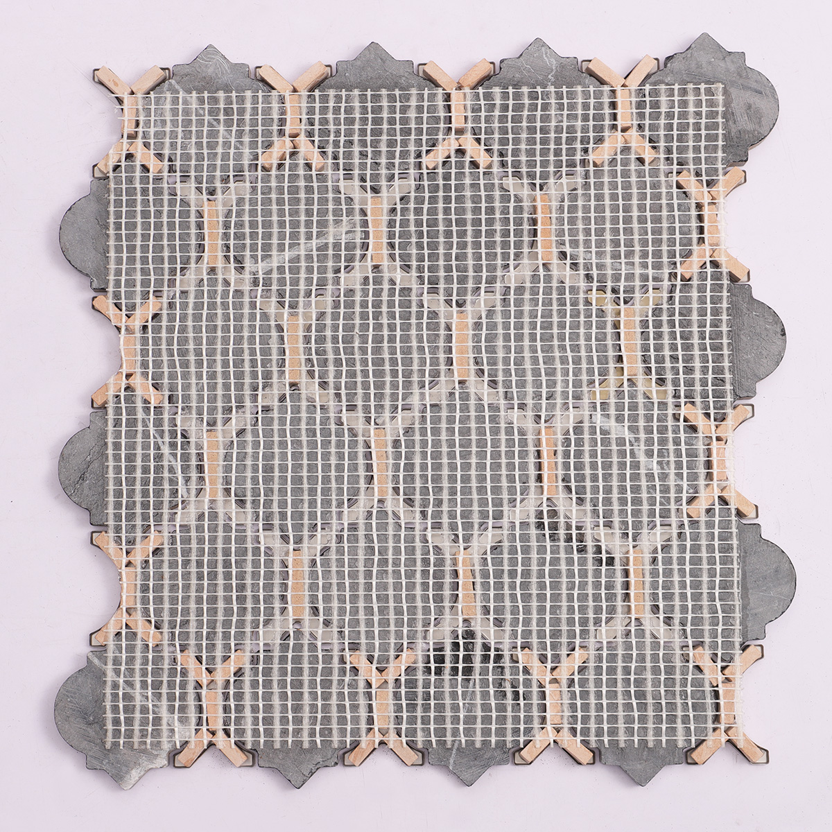 Back side of black marble and gold stainless steel arabesque mosaic tiles, folded.