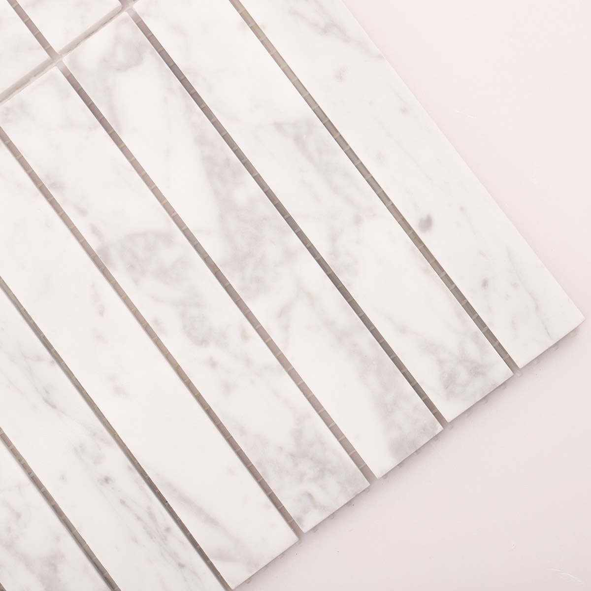 Close-up of Carrara white marble stacked polished mosaic tiles.