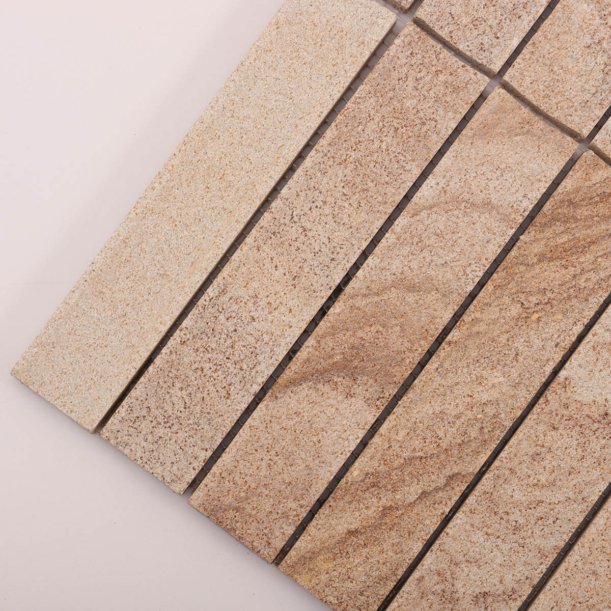 Macro close-up of travertine concave honed fluted strip mosaic tiles.
