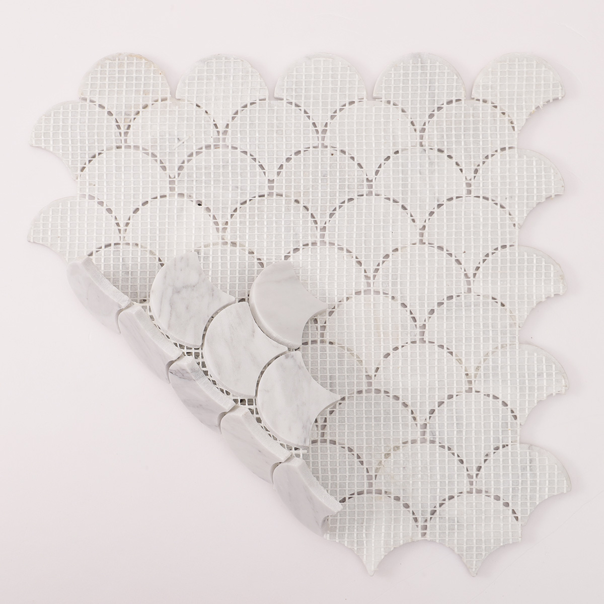 Rear folded view of fish scale fan shape Carrara white marble polished mosaic tiles.