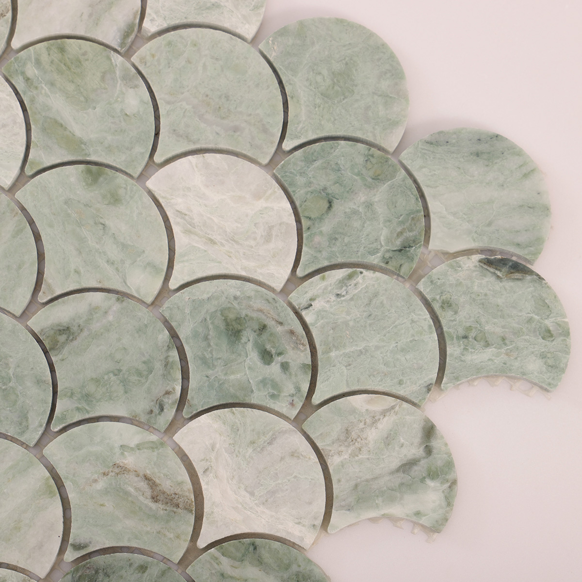Detailed close-up of emerald green marble fish scale mosaic tiles.