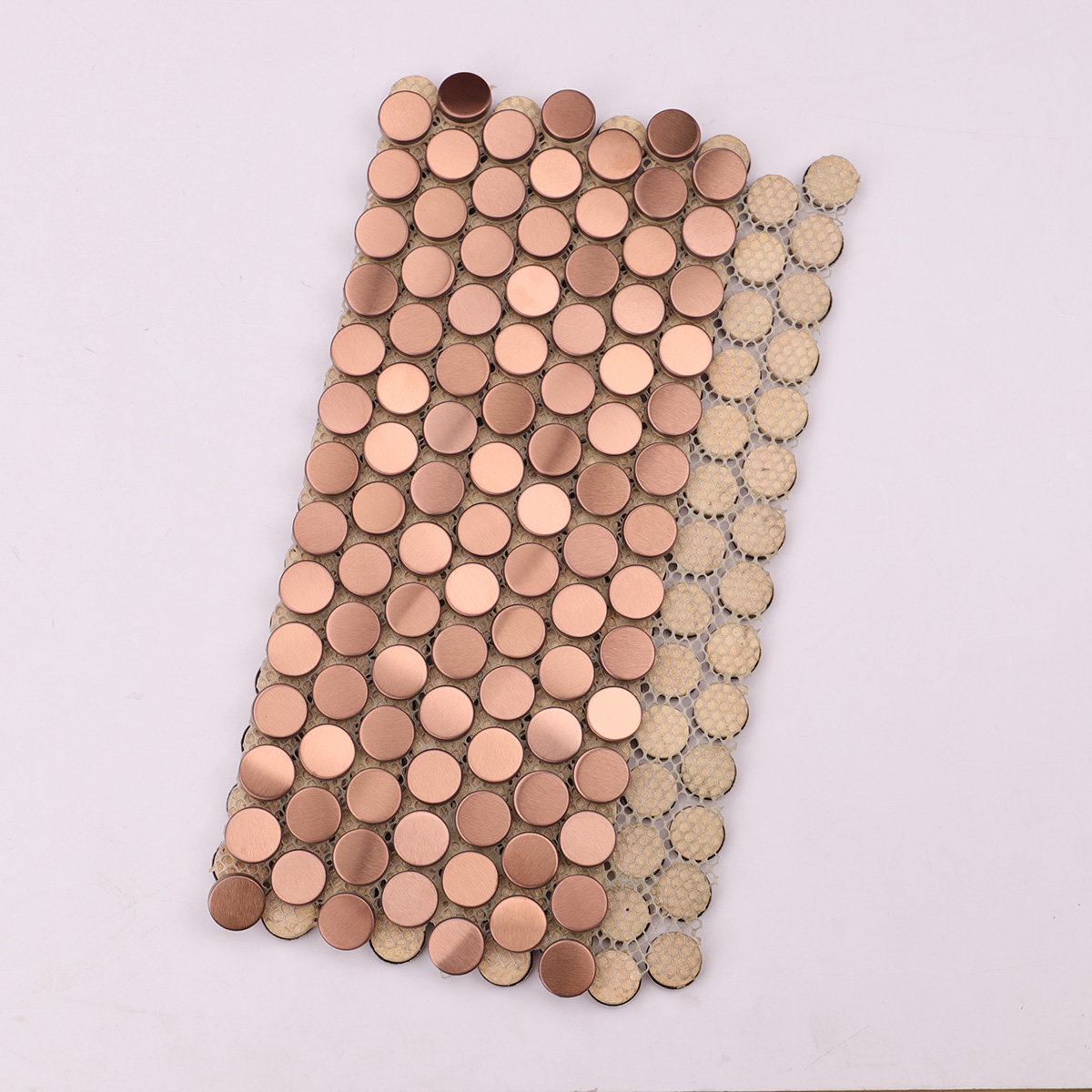 Folded back side of rose gold penny rounds stainless steel metal mosaic tiles.