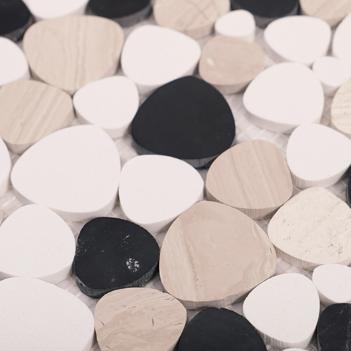 Detailed close-up of white and black flat pebble stone mosaic tiles