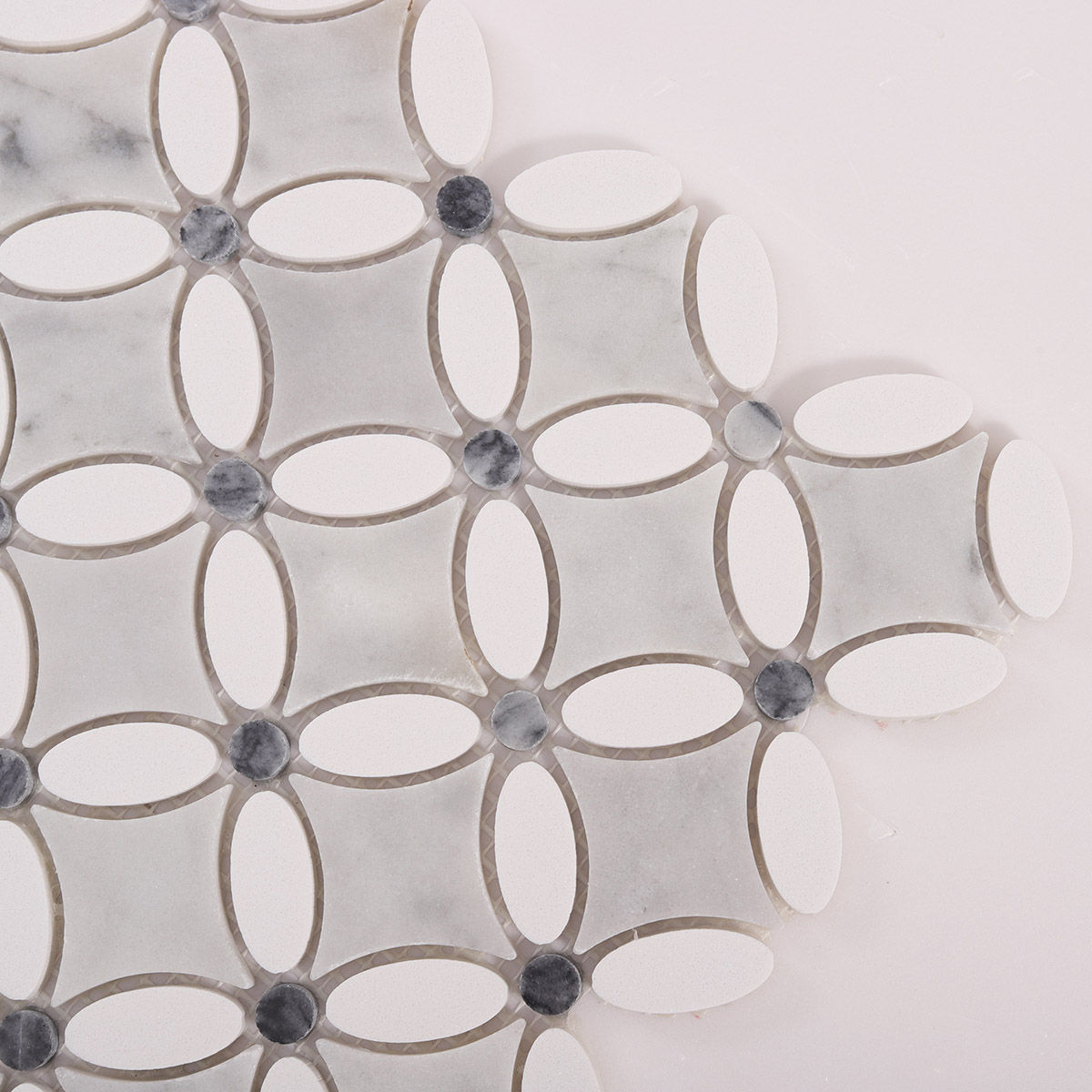 Detailed close-up of thassos gray and white floral marble mosaic tiles