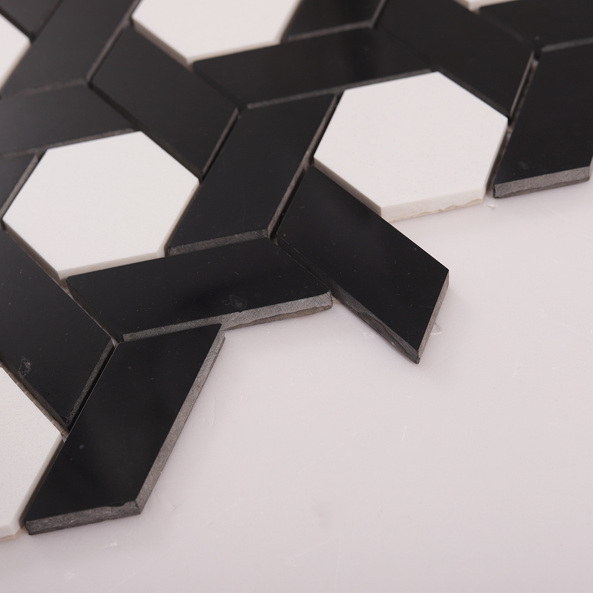 Side close-up view of white and black lattice pattern natural stone mosaic tiles
