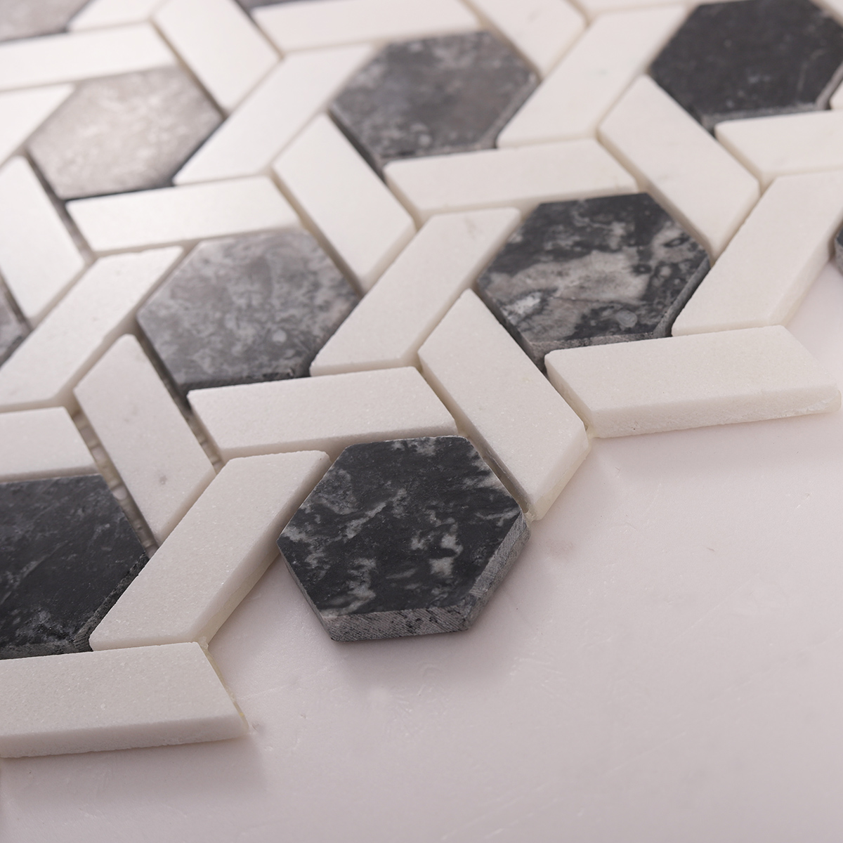 Side close-up view of gray and white hexagonal lattice marble mosaic tiles