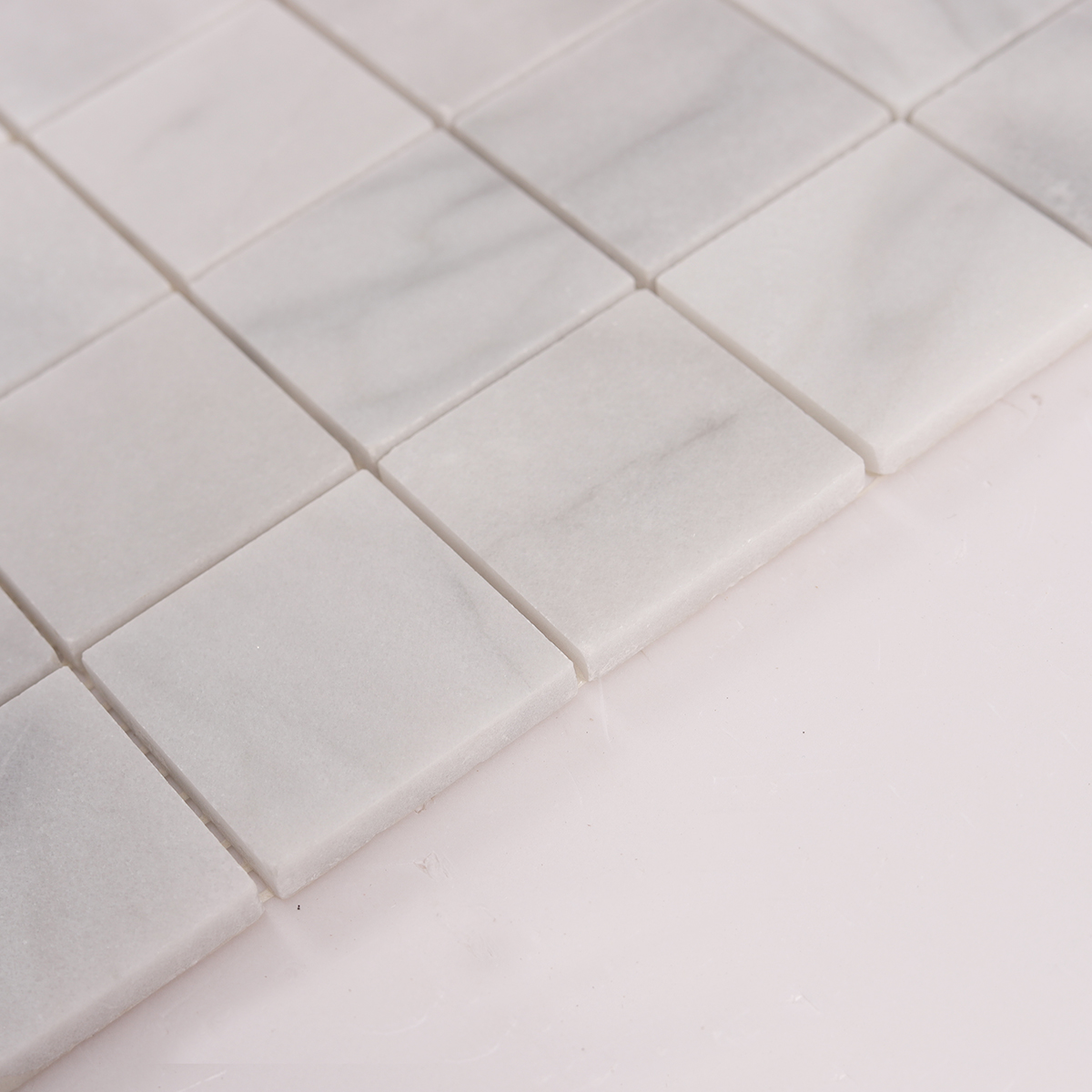 Side close-up view of Carrara Venato Square Marble Mosaic Tiles, showing texture and thickness.