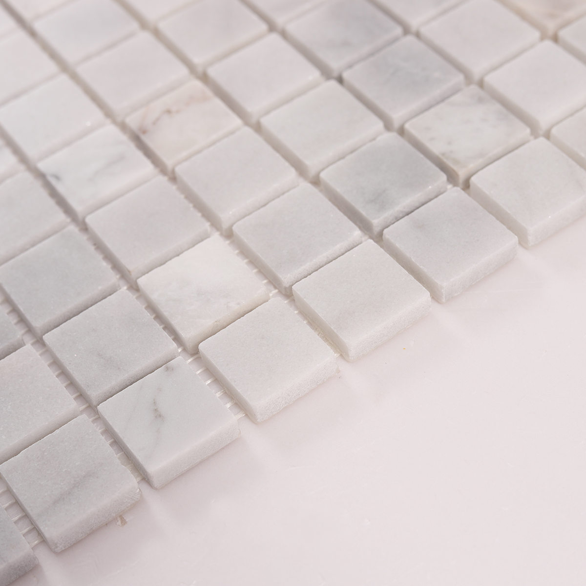 Side close-up view of Carrara Venato Square Honed Marble Mosaic Tiles, showing texture and thickness