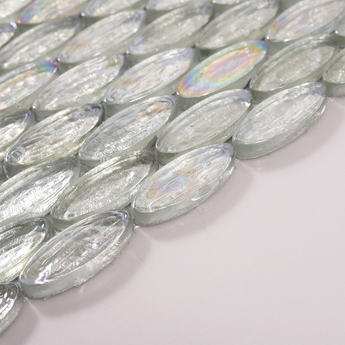 Side view close-up of Oval Silver Iridescent Glass Mosaic Tiles, clean edge detail visible