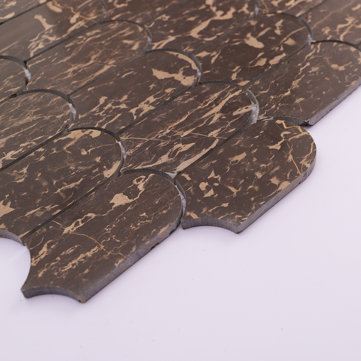 Side thickness detail of dark marble mosaic tile with precise cut edges.