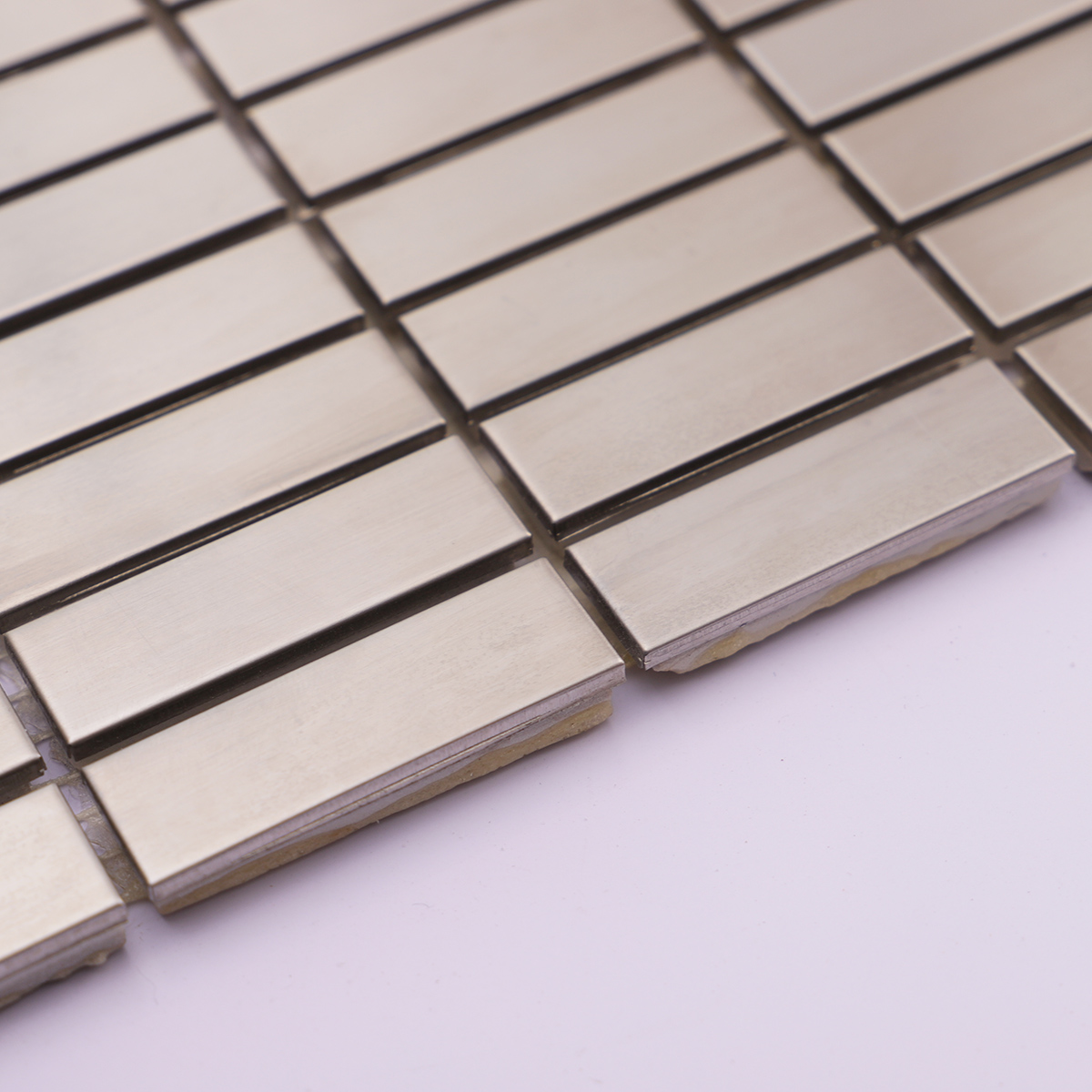 Side profile showcasing the thickness of silver stainless steel rectangle tiles.