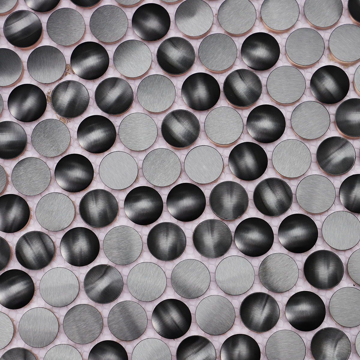 Macro close-up of 3D black penny round metal mosaic tiles.