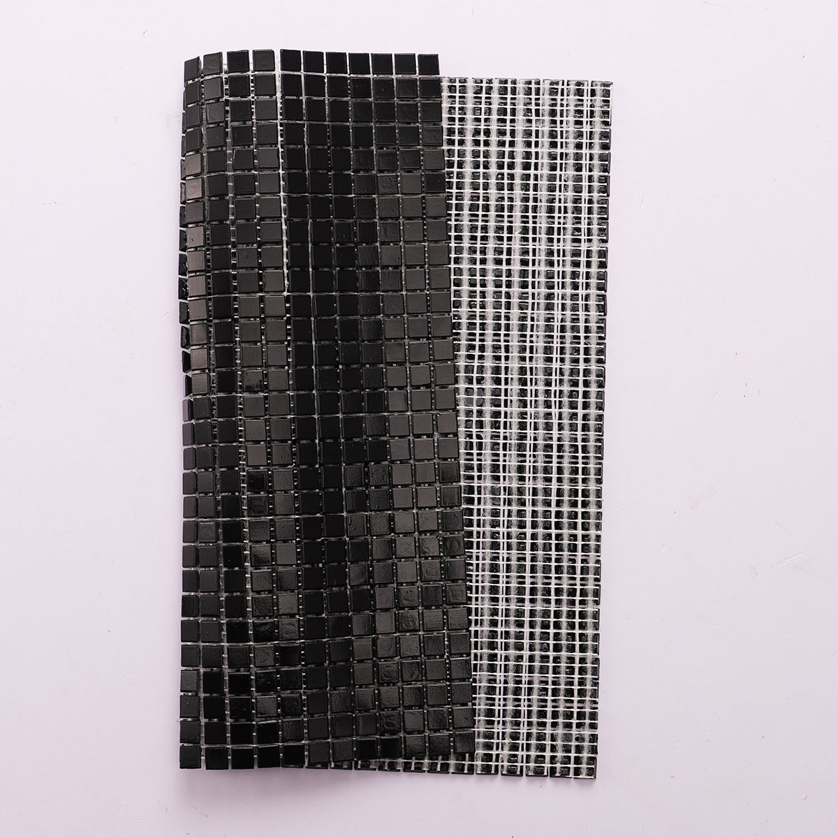 Folded back side of black square glass tiny mosaic tiles 10mm x 10mm.