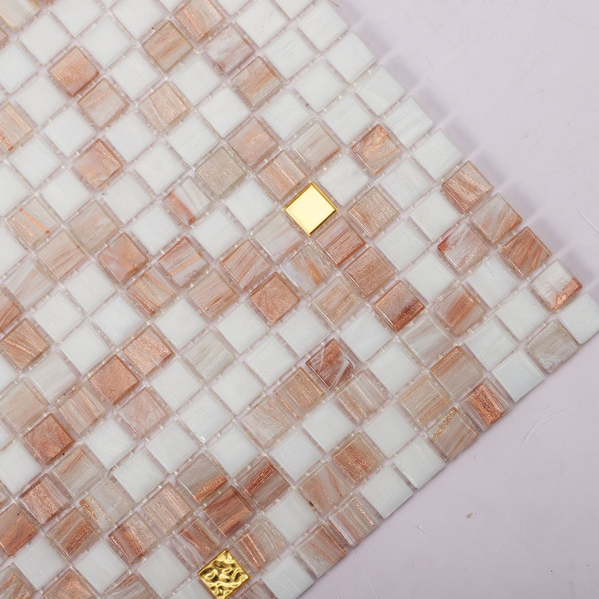 Close-up of white and beige tiny glass mosaic tiles with 24K gold.