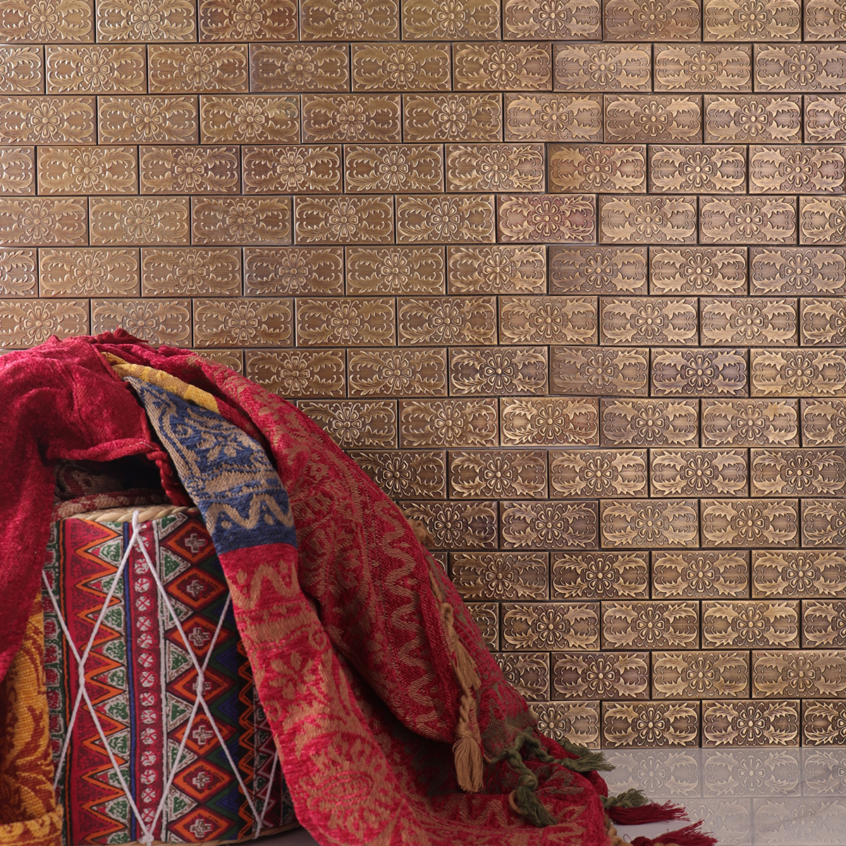Copper subway mosaic with decorative patterns, white floor tiles, and a red stool