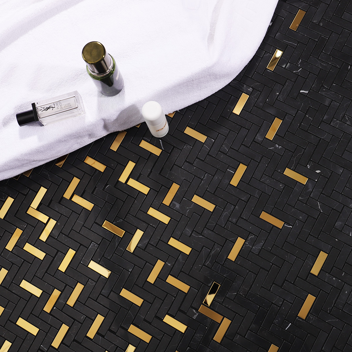 Black marble and gold metal gradient mosaic tiles in a modern bathroom.