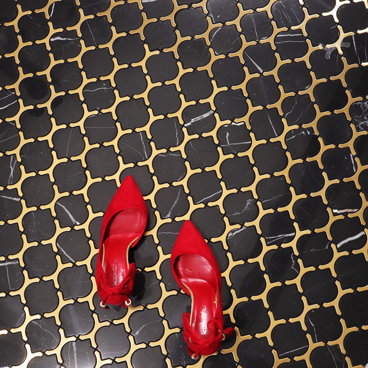 Black marble and gold stainless steel arabesque mosaic tiles on floor.