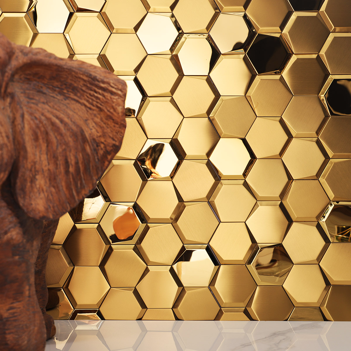 Mirror hexagon gold stainless steel mosaic tiles on the wall with white floor tiles.