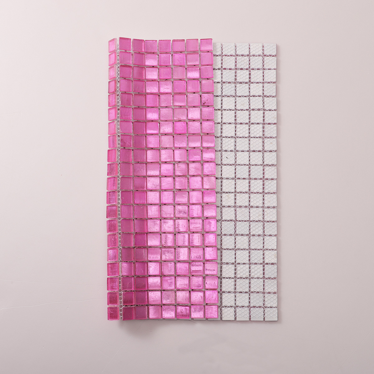 Rear folded view of glossy uniform square pink foil glass mosaic tiles.