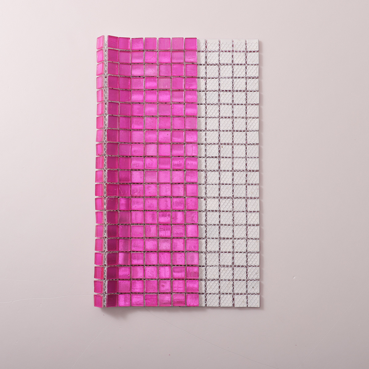 Folded back side of pink foil square glass mosaic tiles.