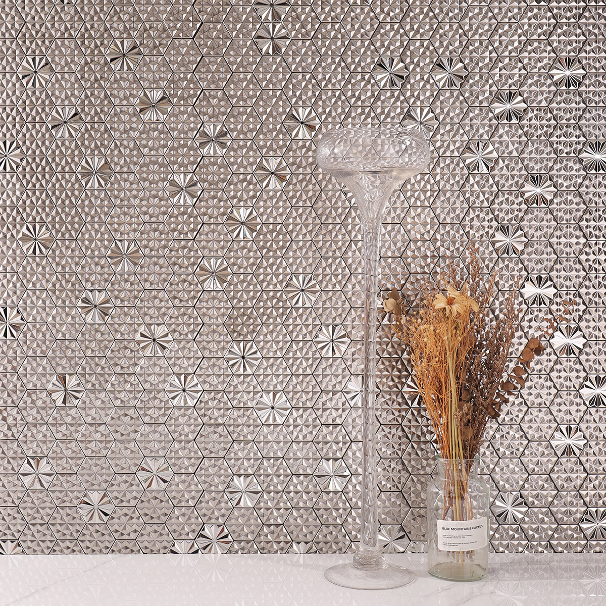 Silver hexagon 3D metal mosaic tiles on a living room feature wall with white floor tiles