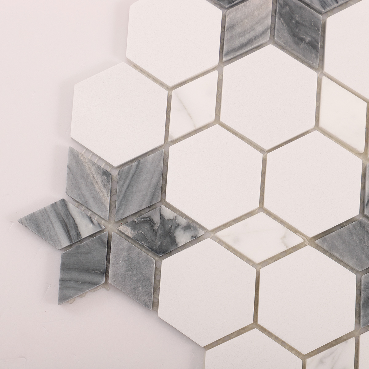 Detailed close-up of white and grey flower marble mosaic tiles.
