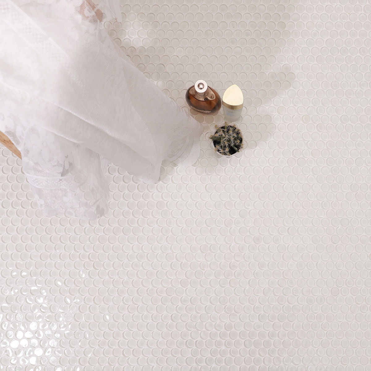 Close-up of white circular mosaic tiles on the floor with decorative items.