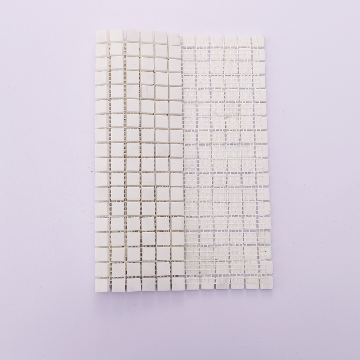 Back view with mesh backing of small square white polished marble mosaic tiles.