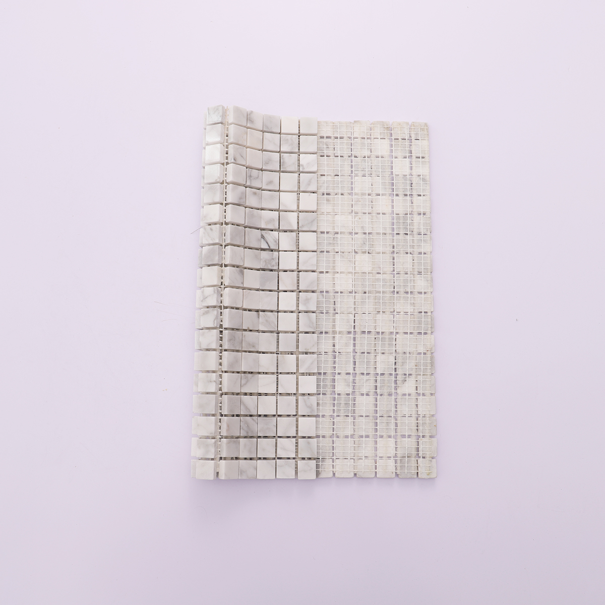Back view showing mesh backing of Carrara white honed marble square mosaic tiles.