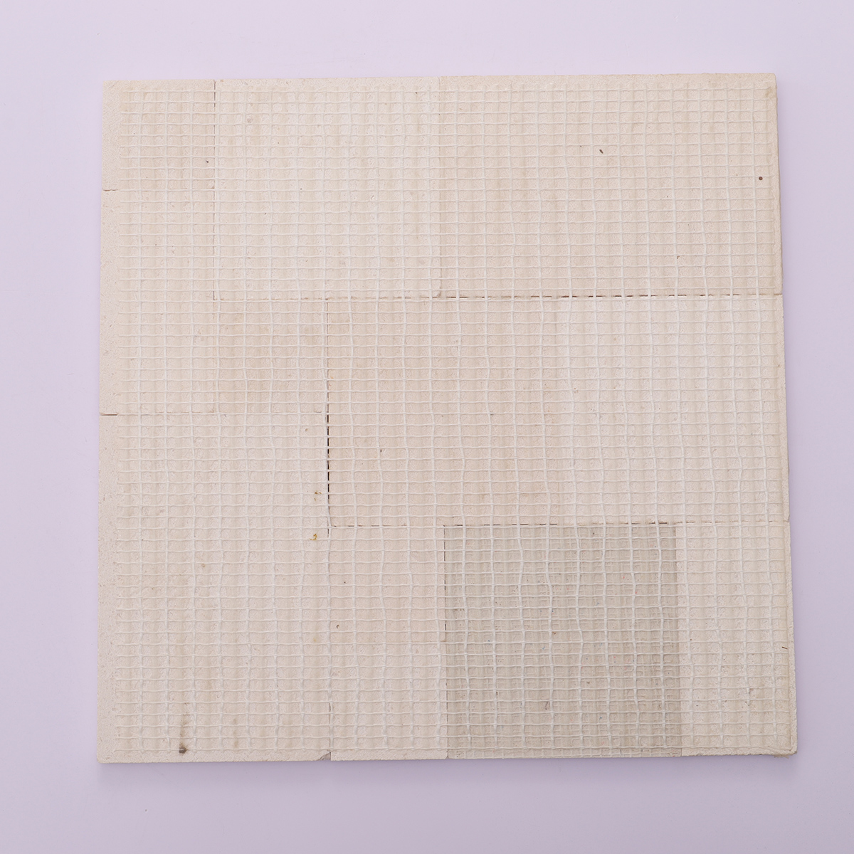 Back view with mesh backing of 3D beige square marble mosaic tiles.