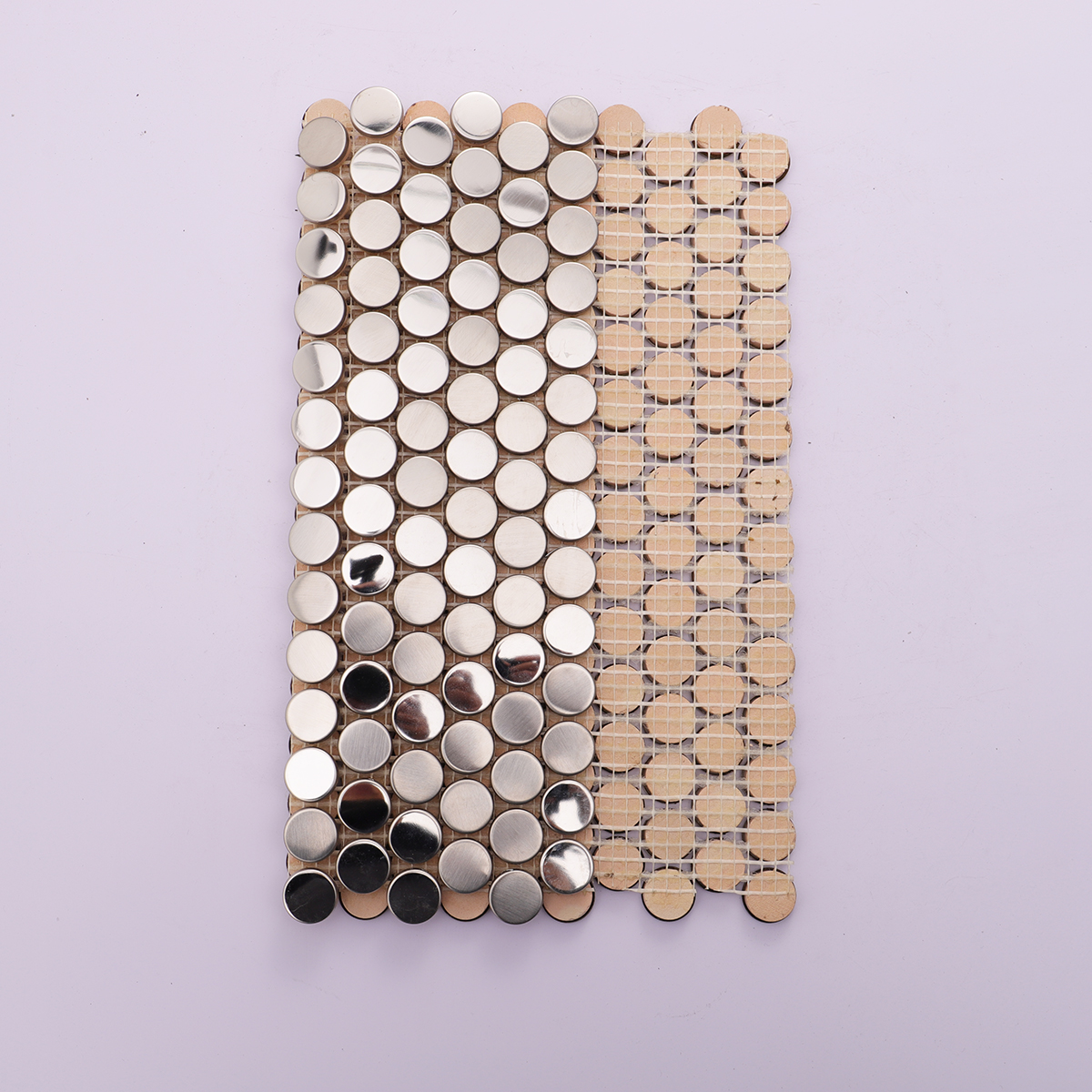Backside of brushed and mirror silver penny tiles, showing mesh backing.