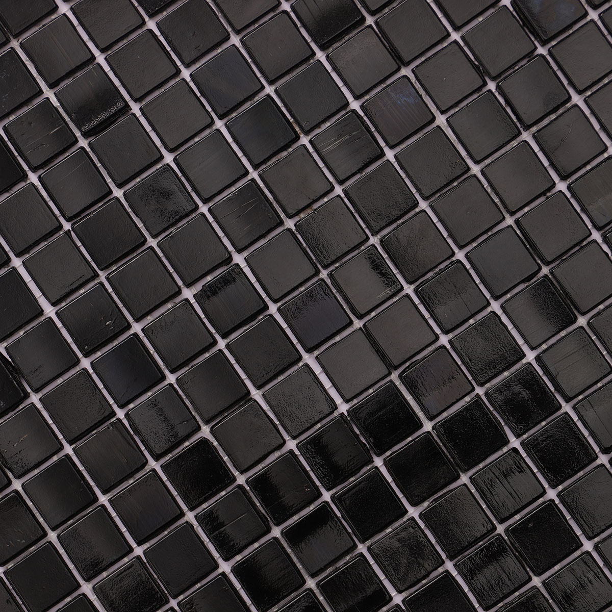 Detailed close-up of pure black glass mosaic tiles.