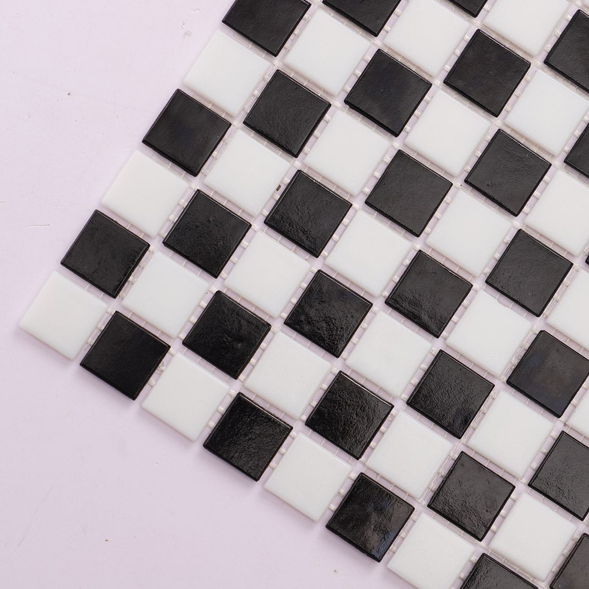 Macro close-up of black and white vintage checkerboard mosaic tiles.
