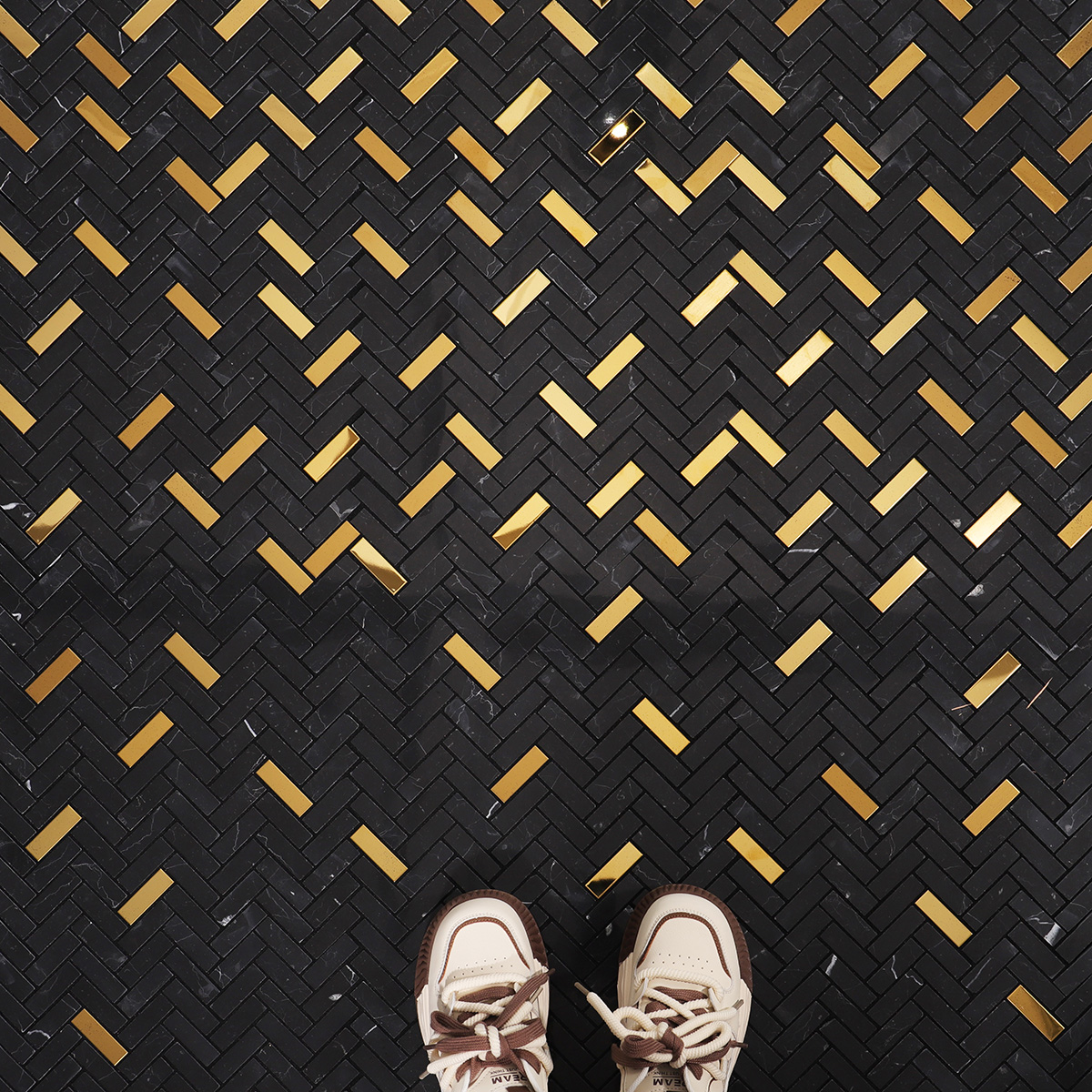 Black marble and gold metal gradient mosaic tiles in a stylish living room.