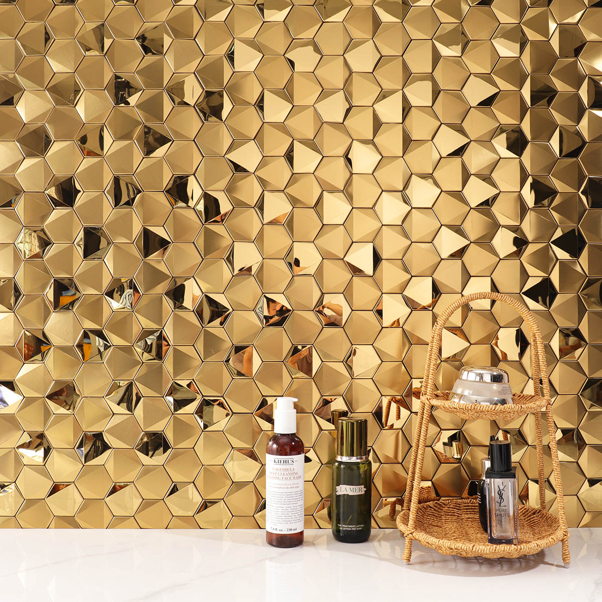 Hexagon gold 3D stainless steel mosaic tiles on a living room feature wall with white floor tiles.