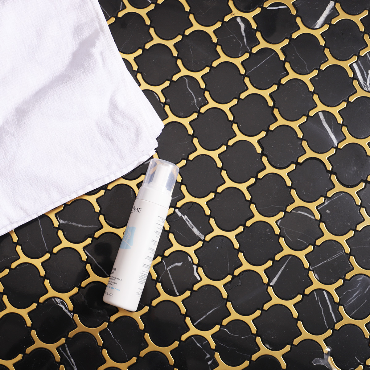Black marble and gold stainless steel arabesque mosaic tiles on bathroom floor.