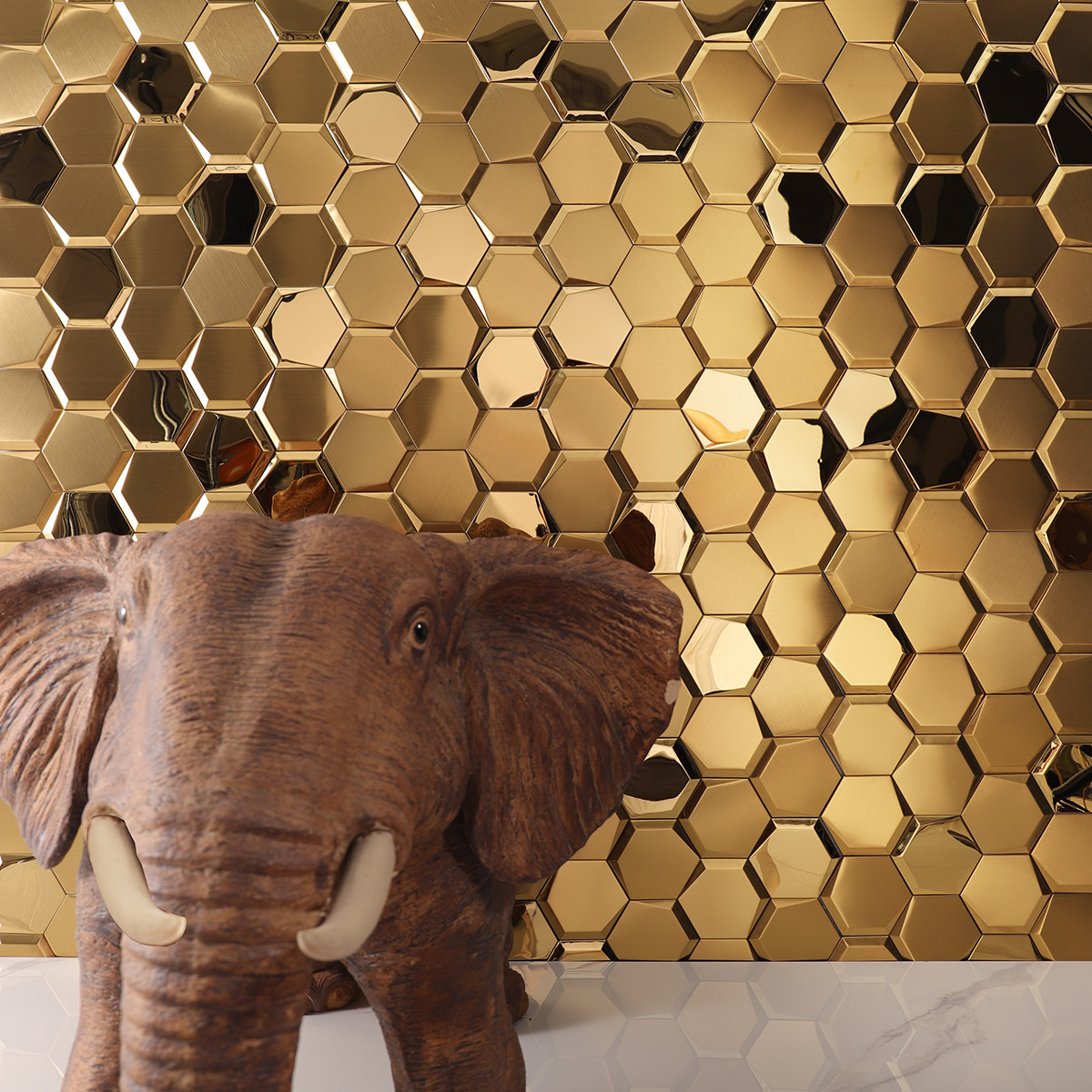 Mirror hexagon gold stainless steel mosaic tiles on a living room wall with white floor tiles.