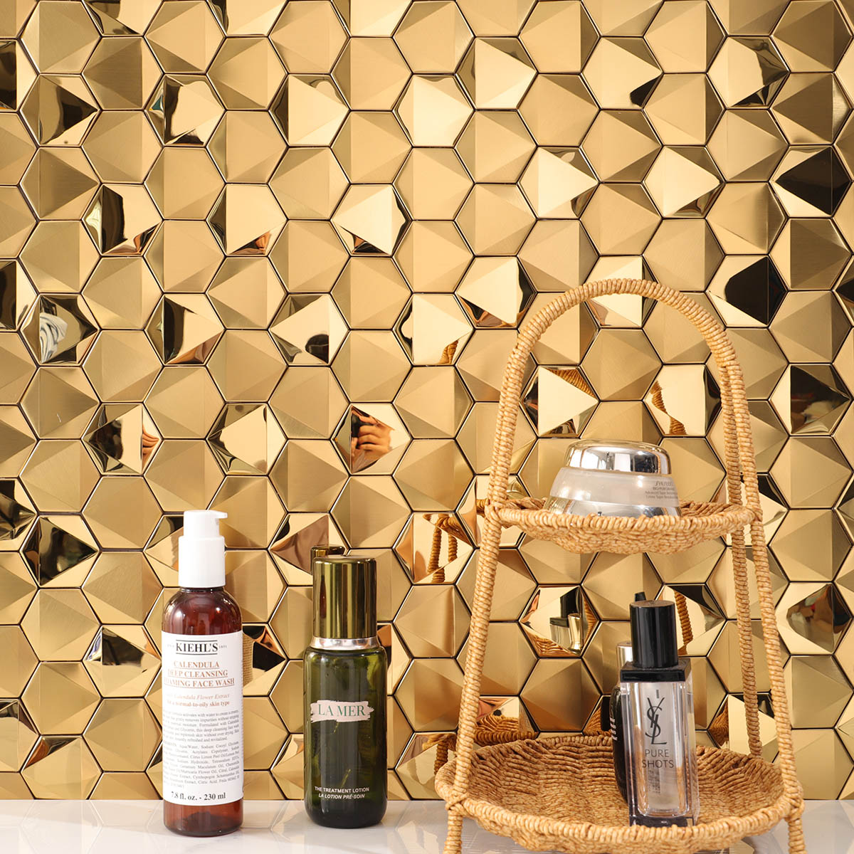 Hexagon gold 3D stainless steel mosaic tiles on the wall with white floor tiles.
